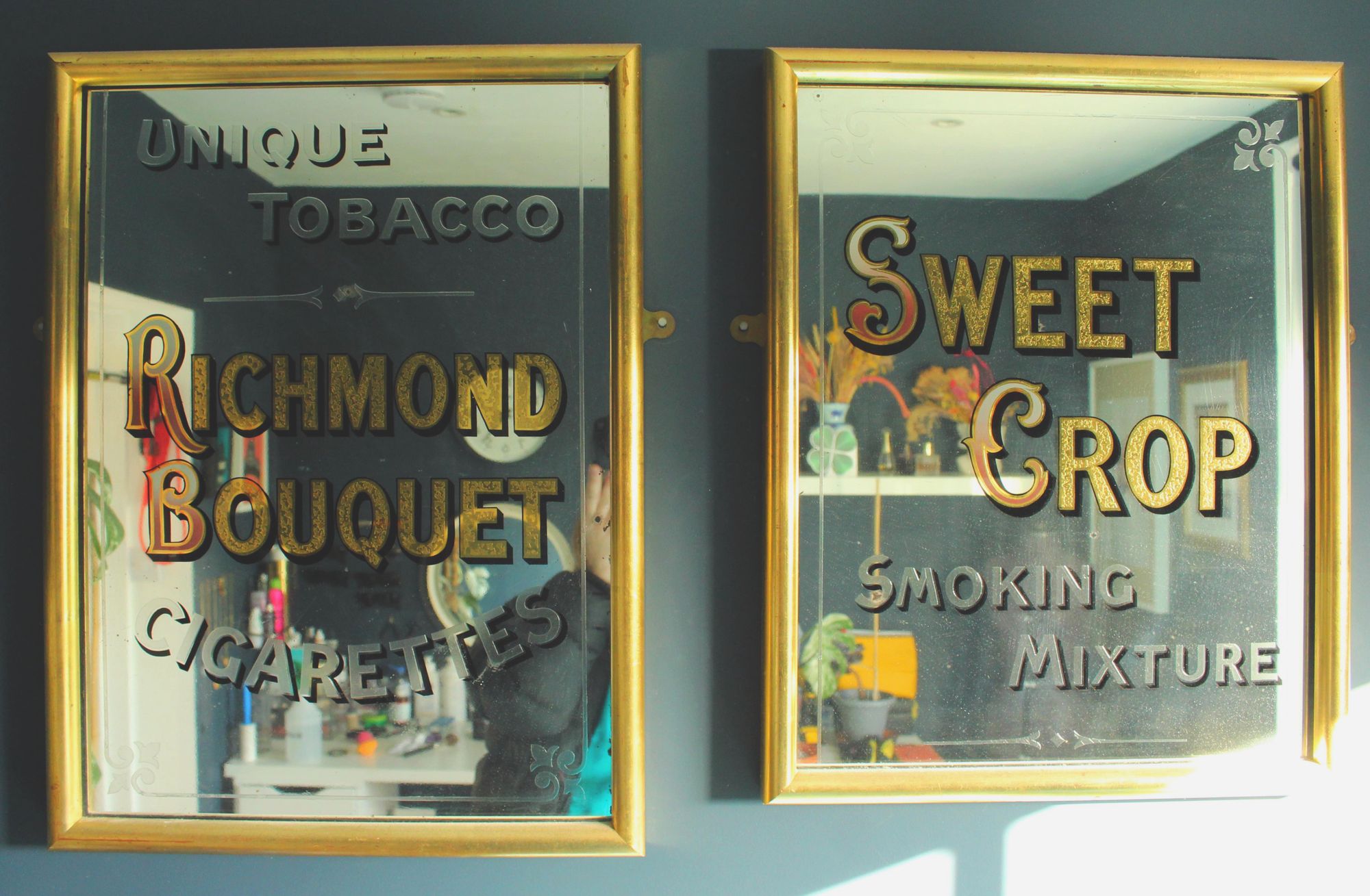 Frame mirrors with gold leaf and painted lettering advertising two tobacco brands.