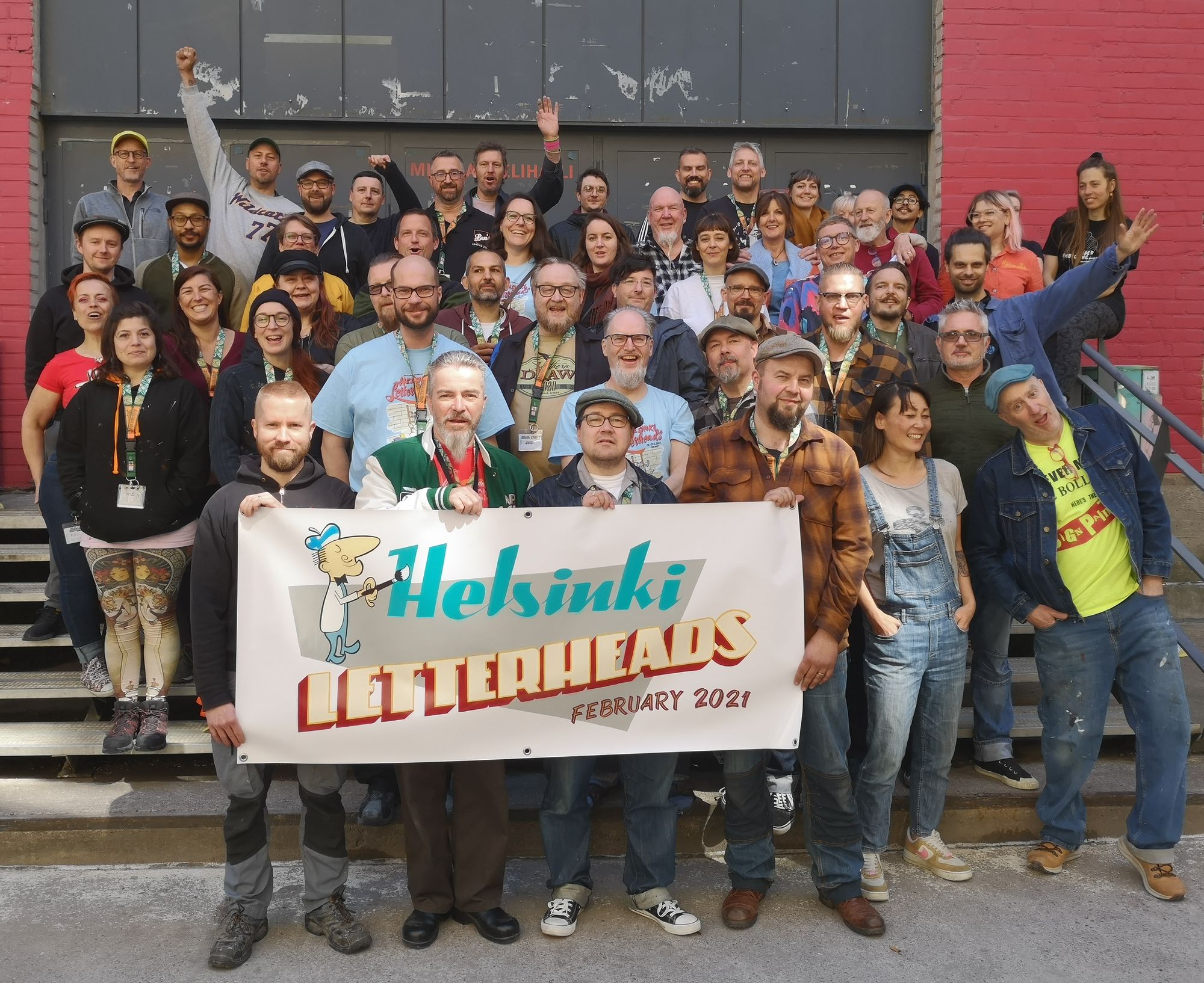 Group of sign painters holding a banner.