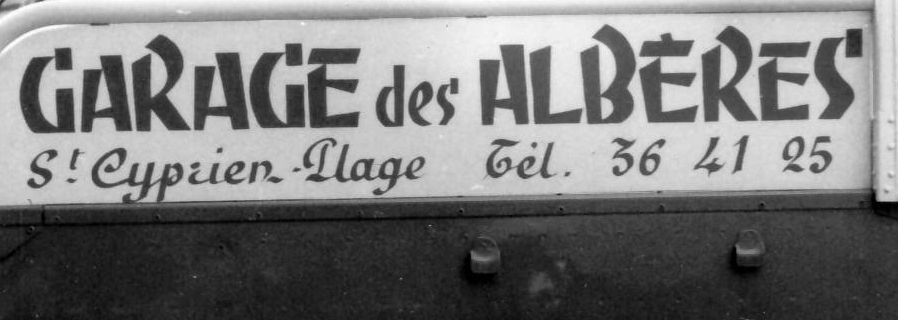 Hand-painted lettering saying 'Garage des Alberes' and giving the garage's location and phone number.