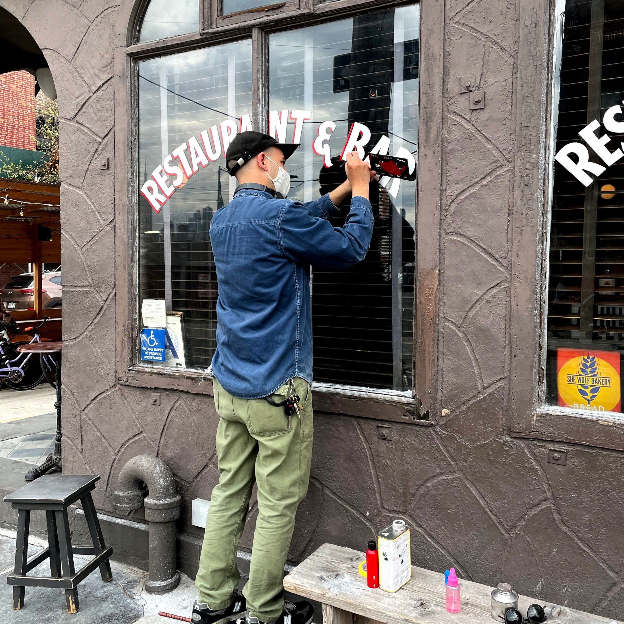 Sign painter lettering a window.