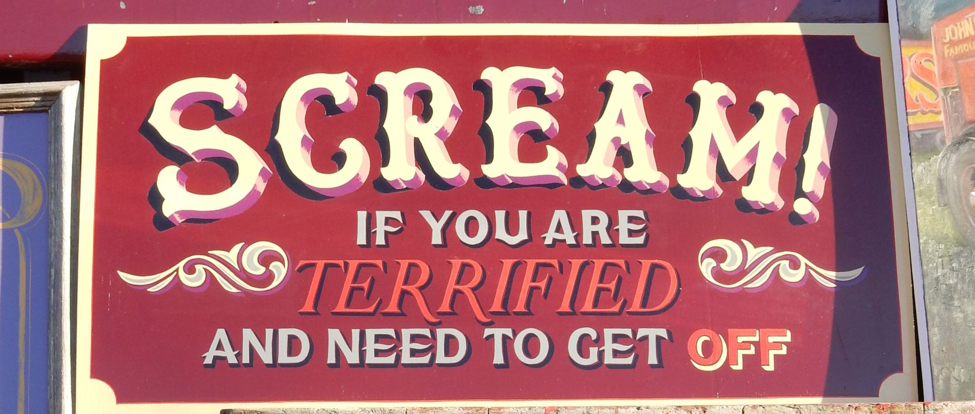 Hand-painted sign that says 'Scream! if you are terrified and need to get off'.