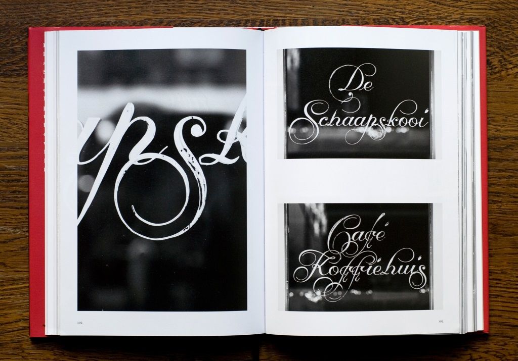 Spread from a book showing black and white photography of elegant painted window lettering.