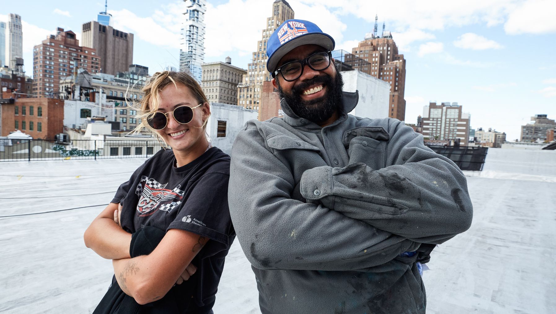 Two people in front of a New York skyline.