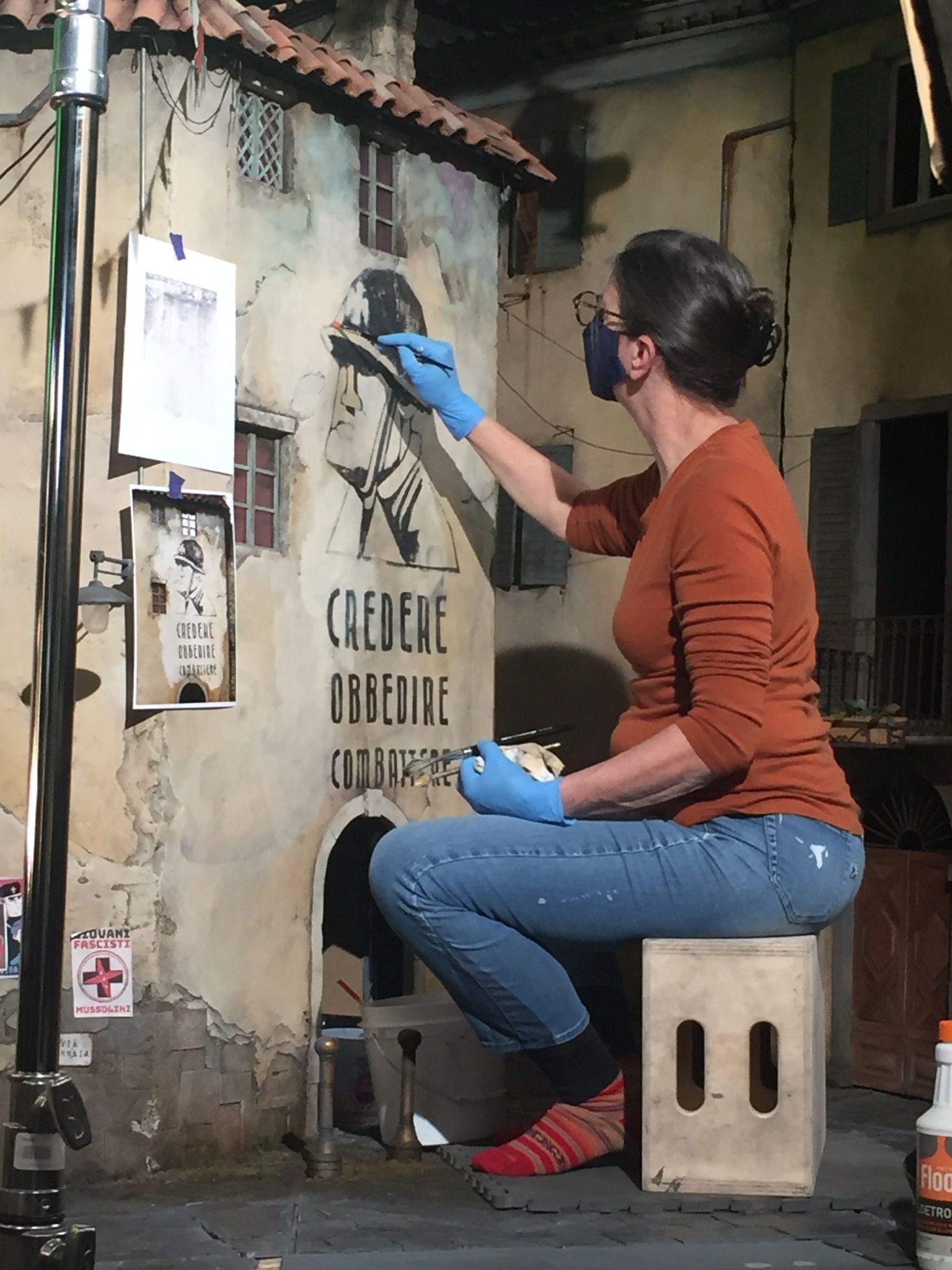 Woman painting a scale model of a building.