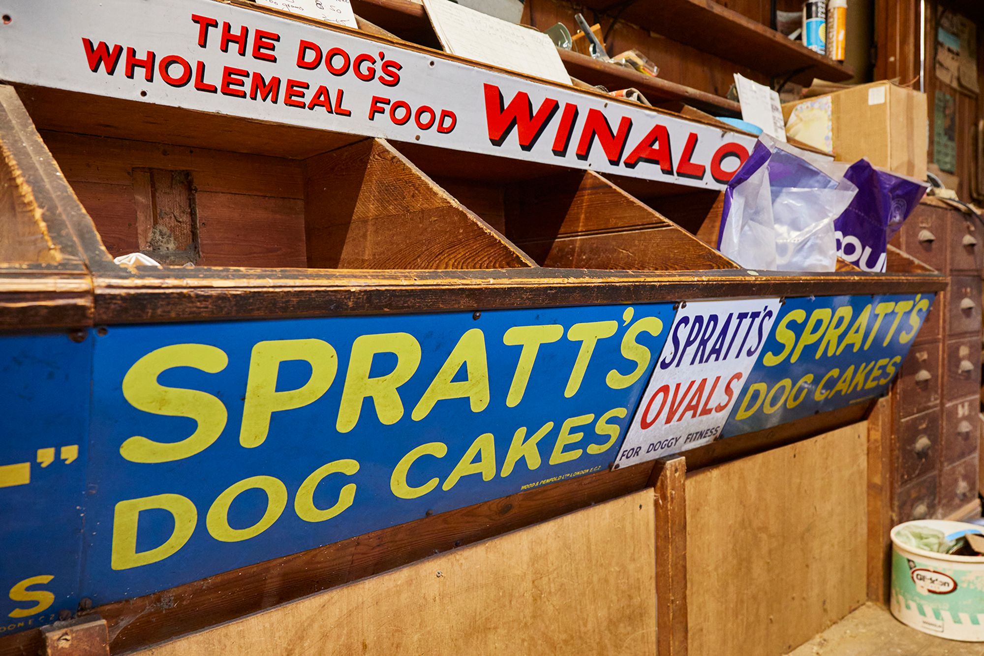 Lettered signs in front of animal feed boxes.