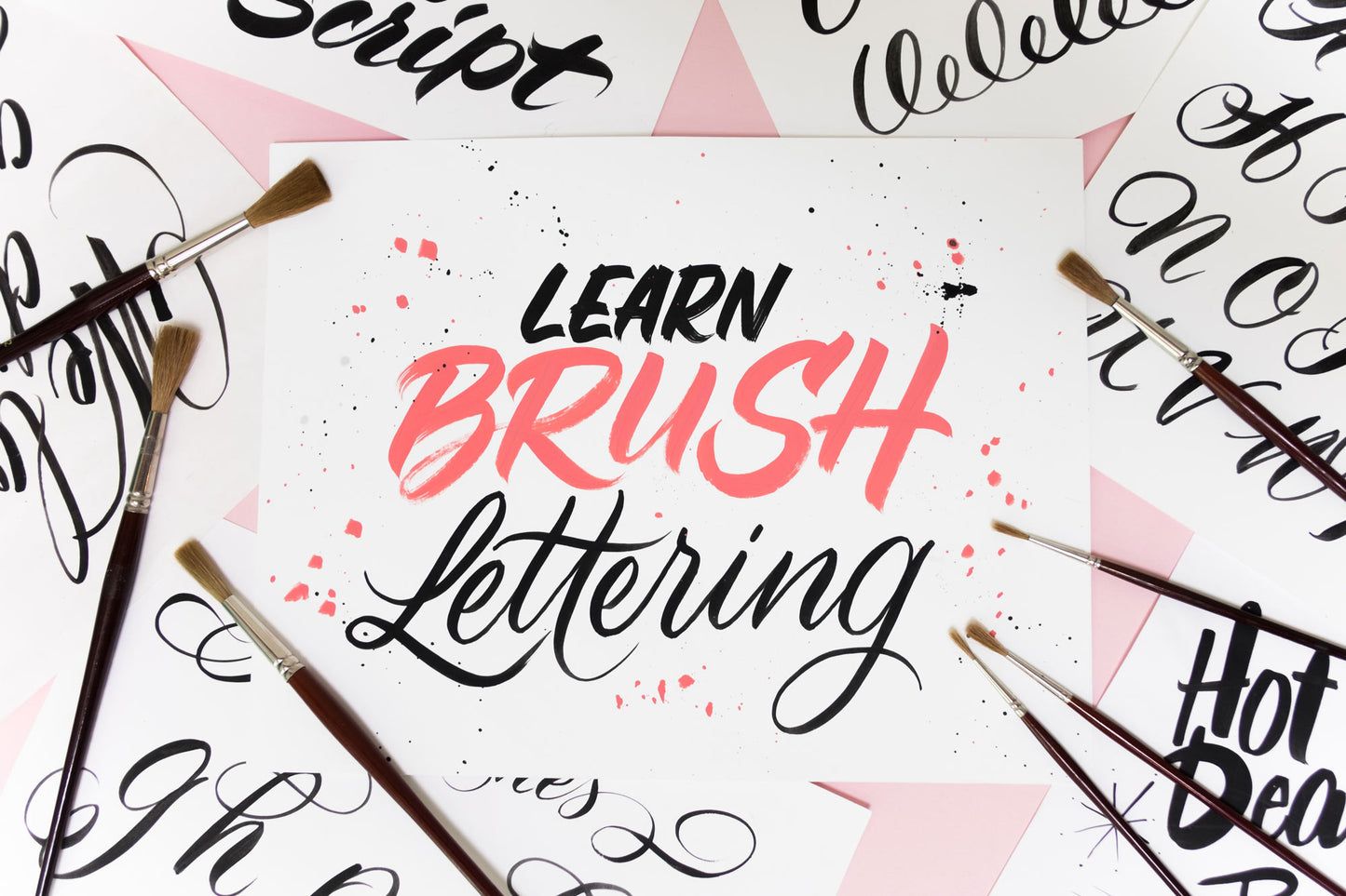 Brushes and sheets of paper with brush lettering on them.