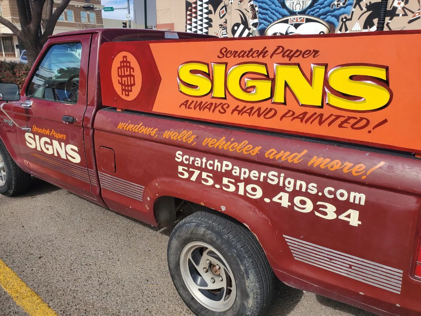 Truck with hand-painted lettering on the sides and sidings.