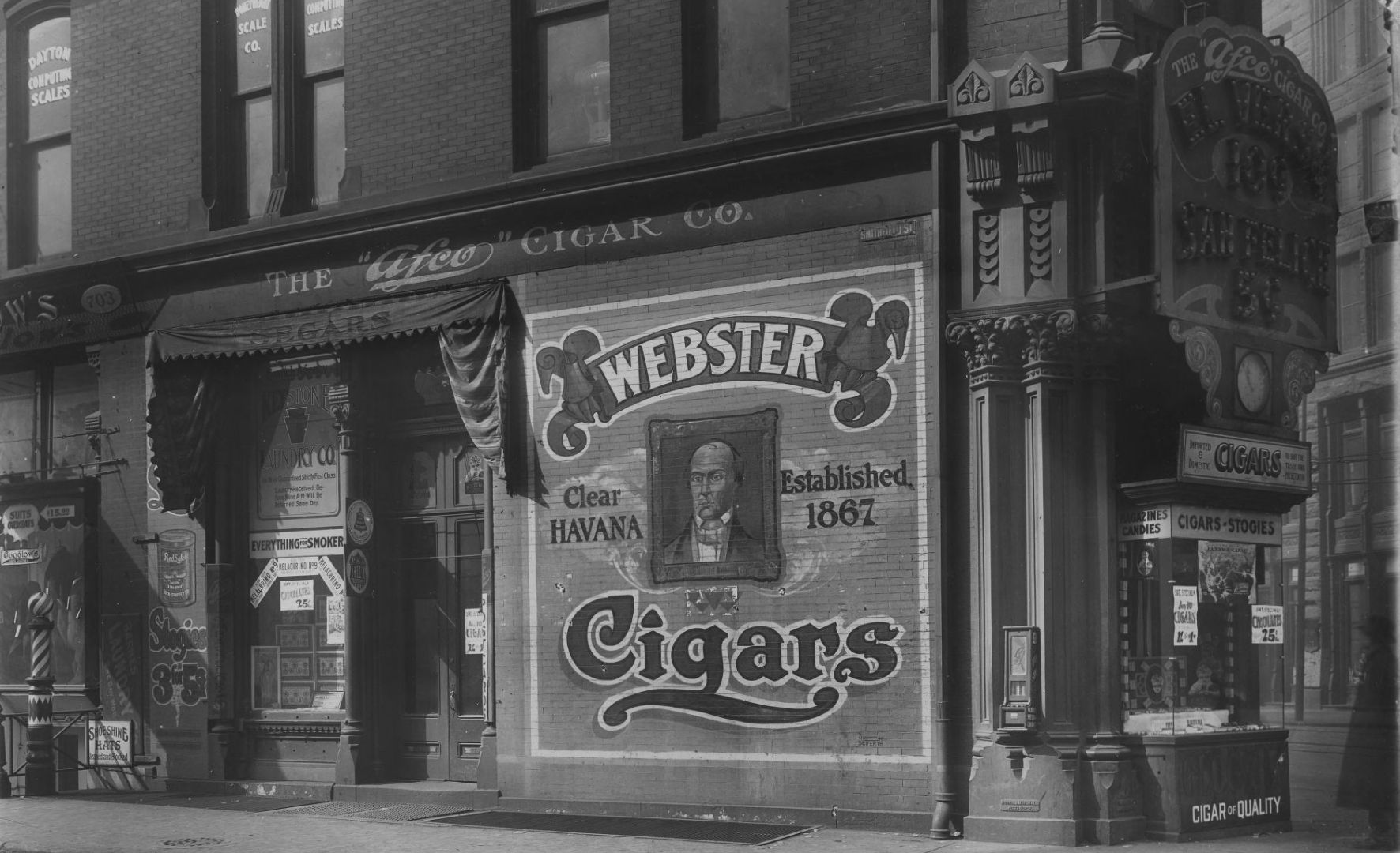 Cigar shop with a medley of signage, including a painted wall, fascia, illuminated piece, window displays and more.