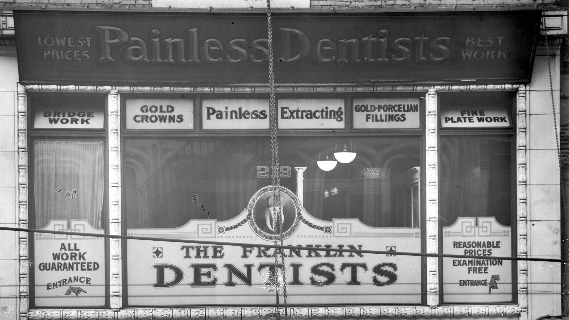 Fascia sign and numerous pieces of window signage advertising the "Painless Dentists".