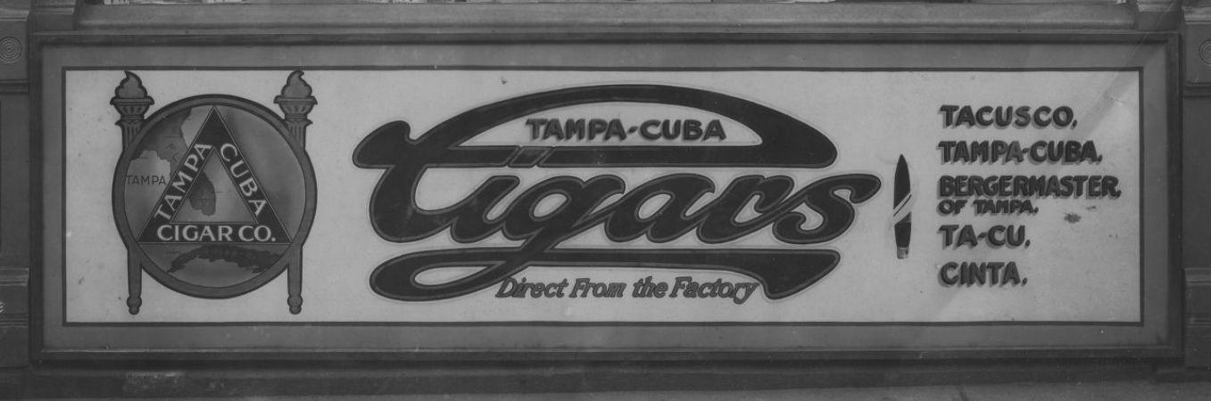 Glass sign set within a wooden frame with branding and lettering for Tampa-Cuba Cigars.