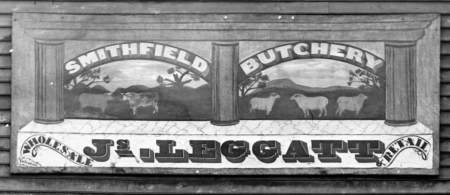 Hand-painted sign with pictorials of cows and sheep, and lettering that reads 'Smithfield butchery, Js. Leggatt, Wholesale, Retail'.