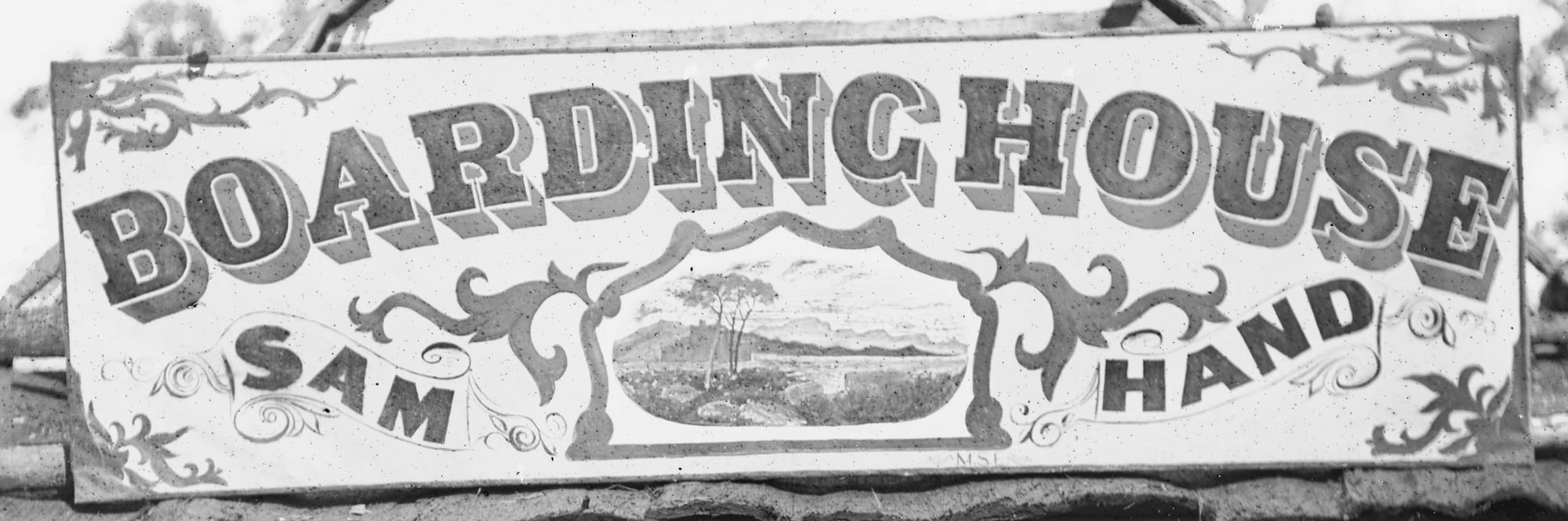 Hand-painted sign board with scrolling, a rural scene pictorial, and lettering that reads 'Boarding house, Sam Hand'.
