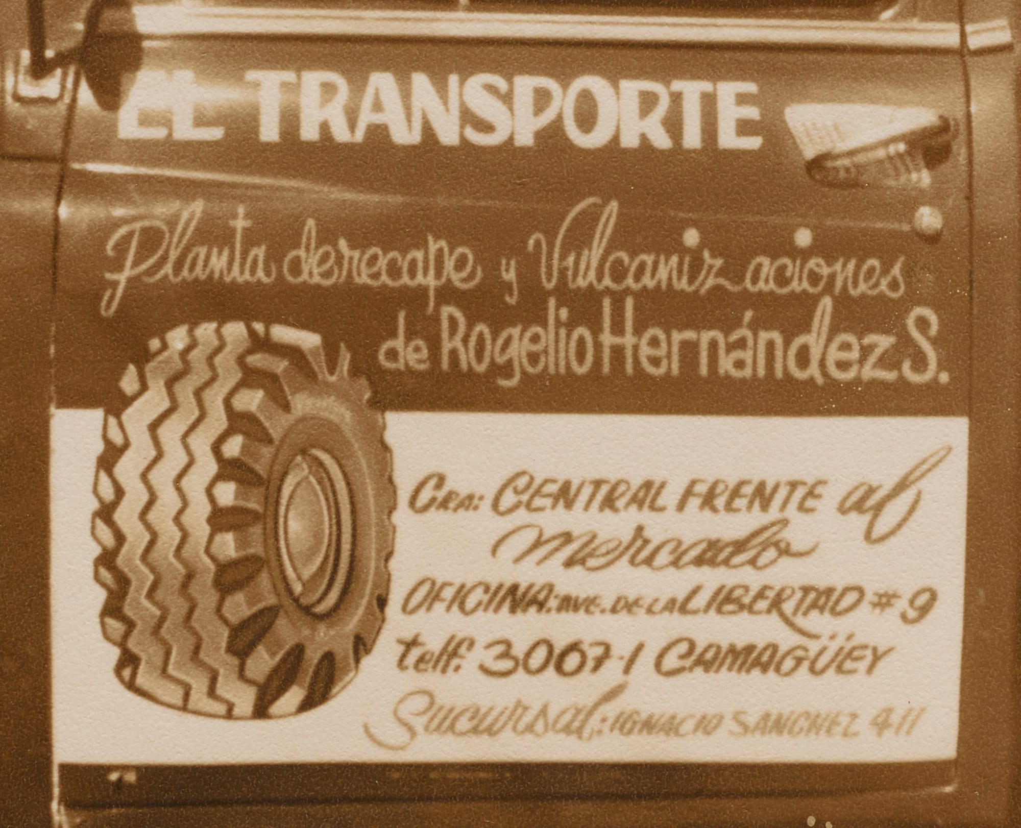 Detail of a hand-lettered truck door with a picture of a tyre and lettering for "El Transporte".