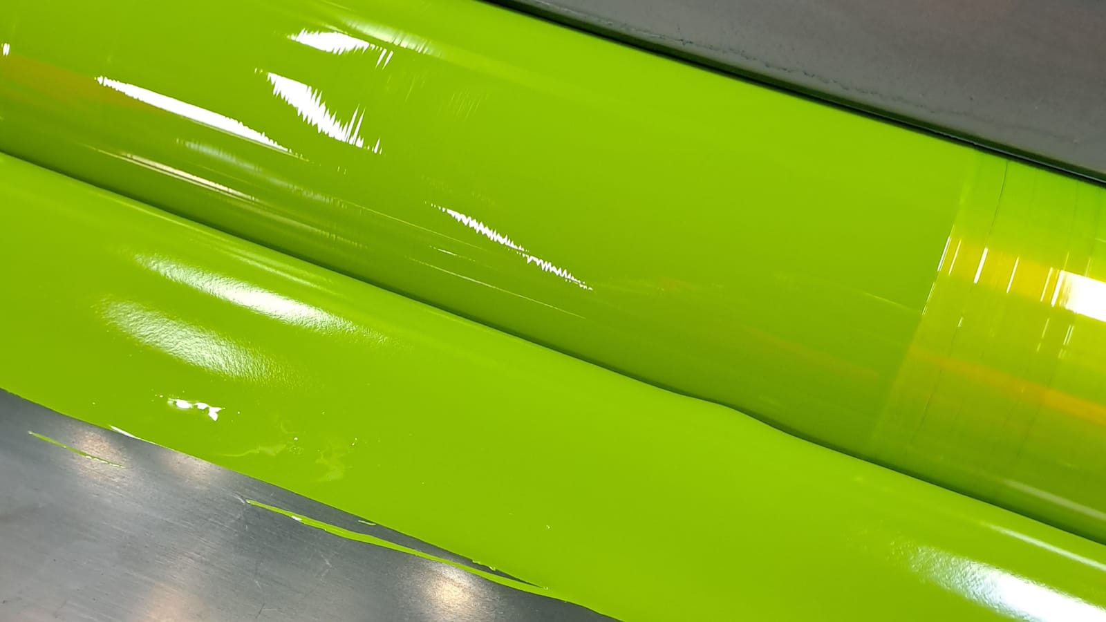 Two rollers with a bright yellow-green ink on them.