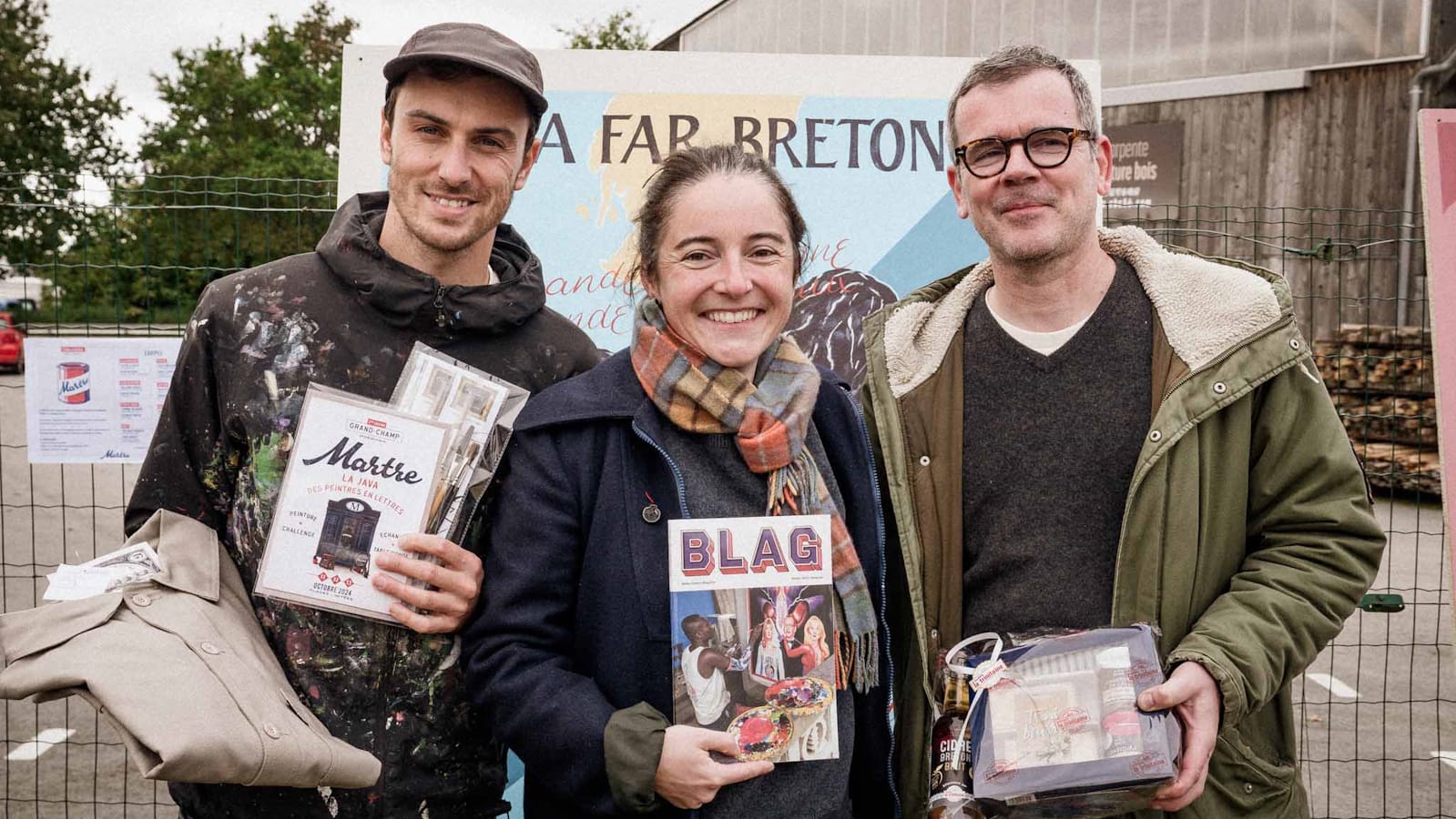 Three people posing for a photo with prizes they've won.