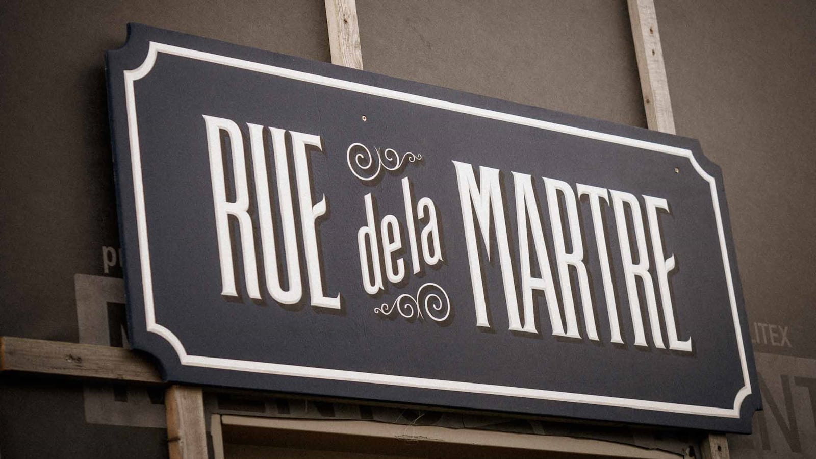 Painted sign in white out of dark blue that reads "Rue de la Martre"