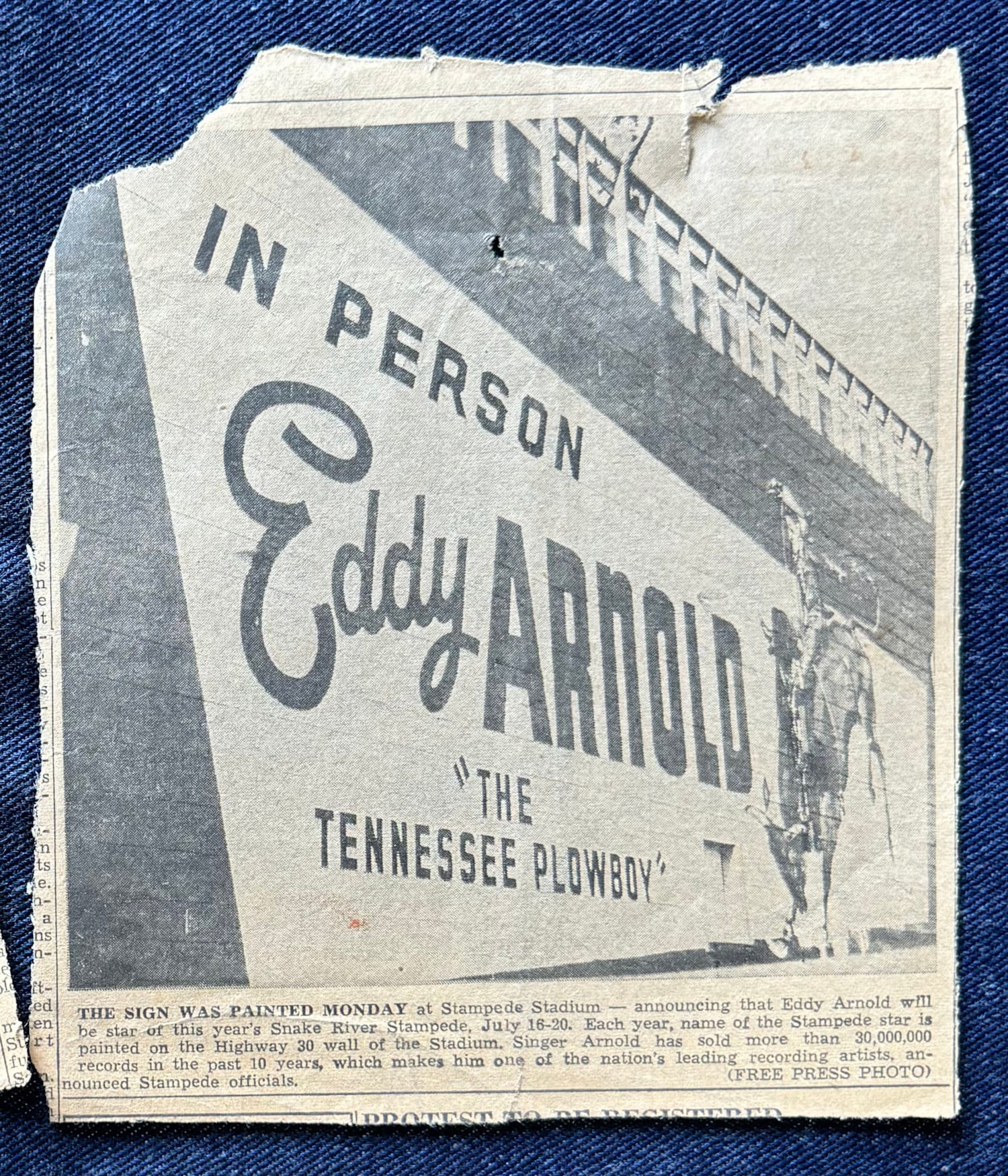 Large wall sign with a pictorial of a mounted cowboy and lettering that reads "In Person: Eddy Arnold, 'The Tennessee Plowboy"