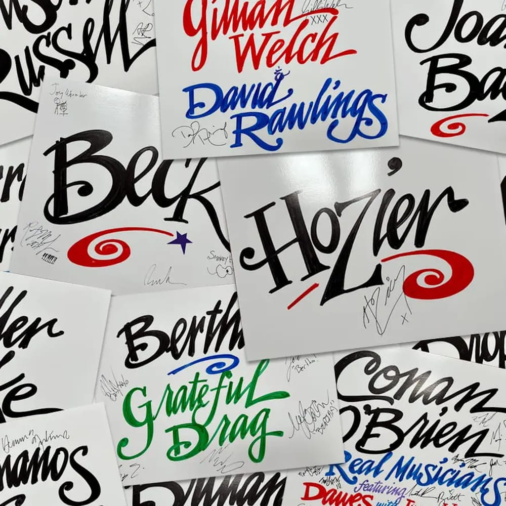 Cards with vibrant pen lettering giving the names of various jazz acts, each signed in smaller pen.