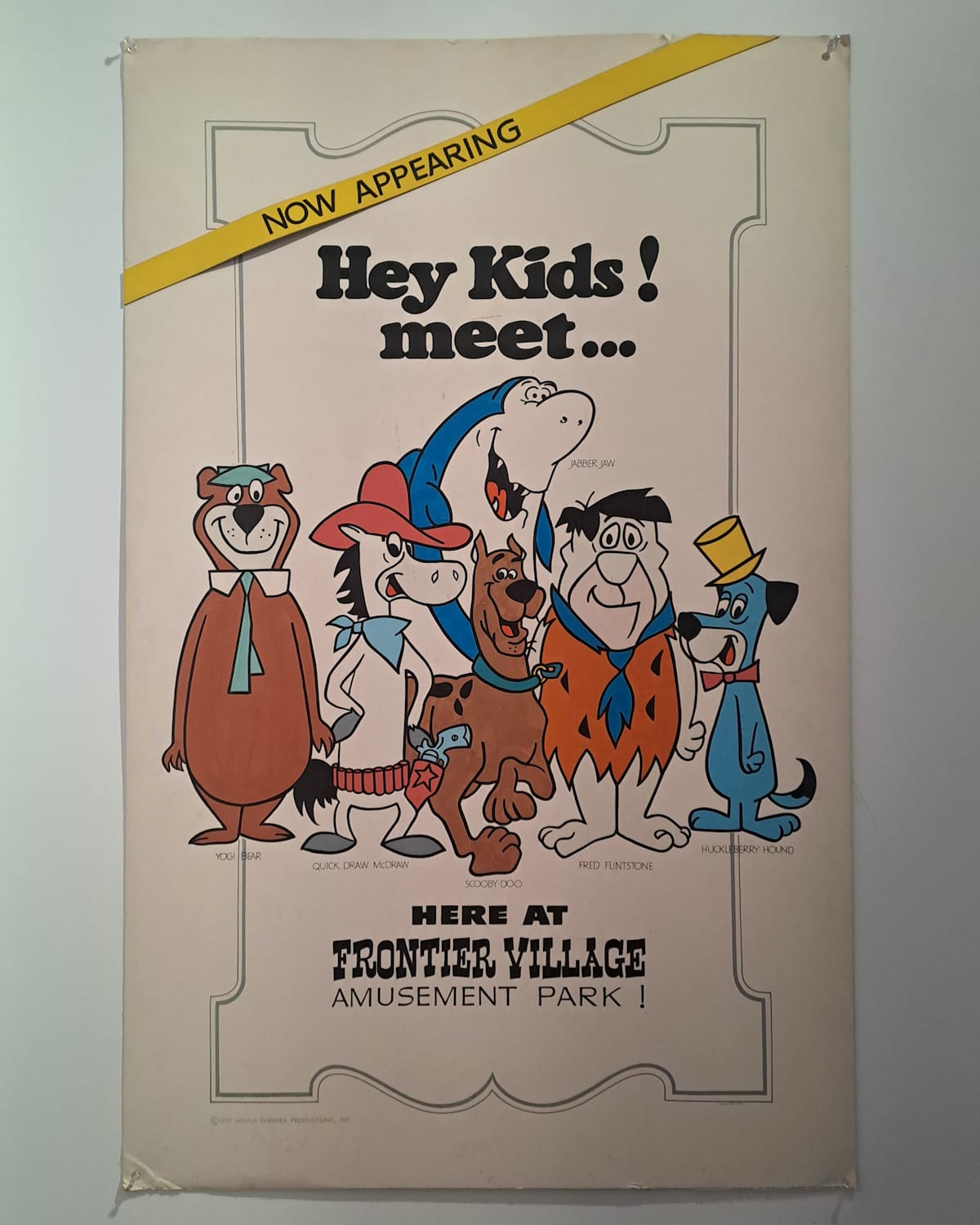 Showcard advertising the Hanna-Barbera Frontier Village amusement village, and illustrated with some of their most famous cartoon characters, including Yogi Bear, Scooby Doo, and Fred Flintstone.