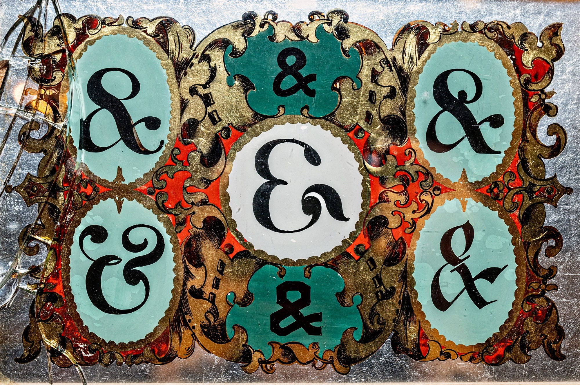 Seven different ampersand variants painted in black on different shades of turquoise backgrounds and set within decorative gilded scrollwork.