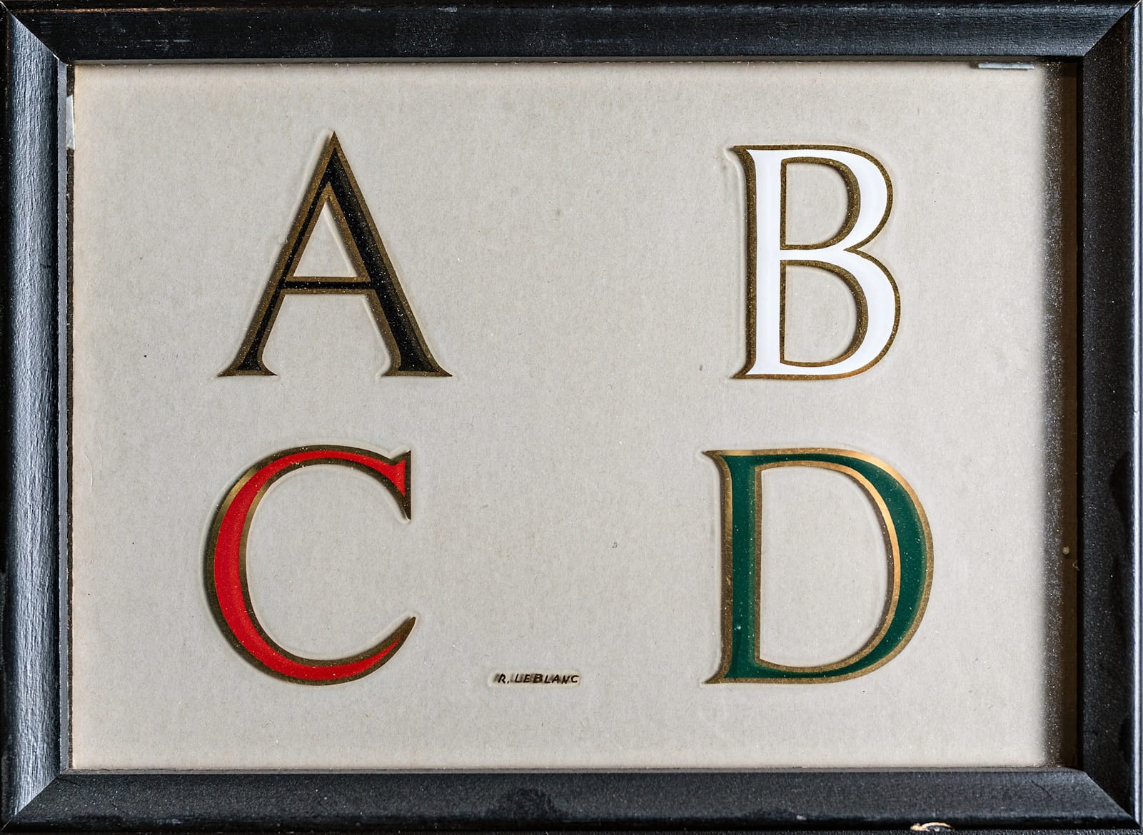Four Roman letters — A, B, C, and D — on a glass panel. Each has a gilded outline and painted centre. The centre of the A is black, the B white, the C red and the D green.