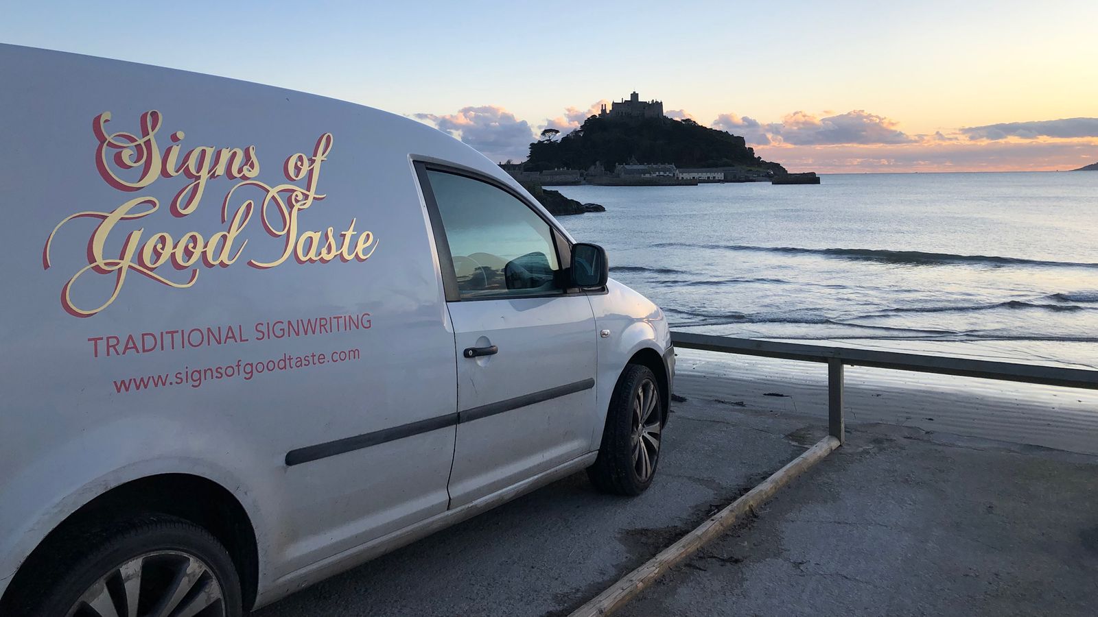 White van with gilded lettering facing the sea.