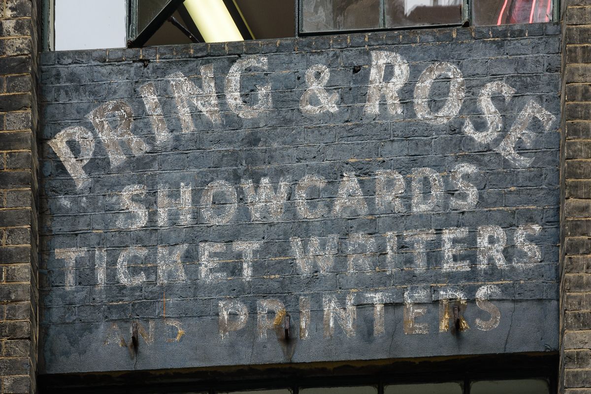 Fading painted sign on brick.