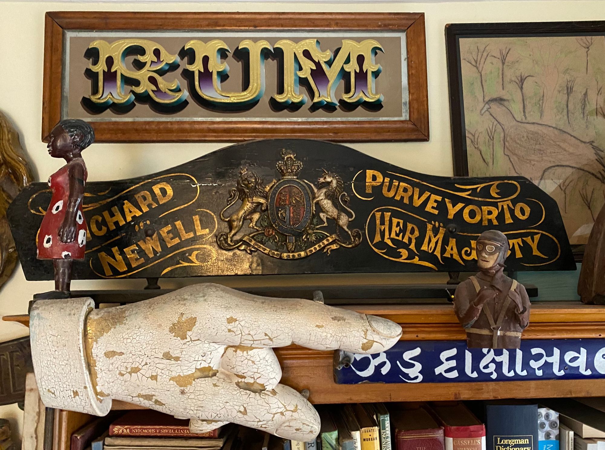 Various signs on display near the top of a bookshelf.