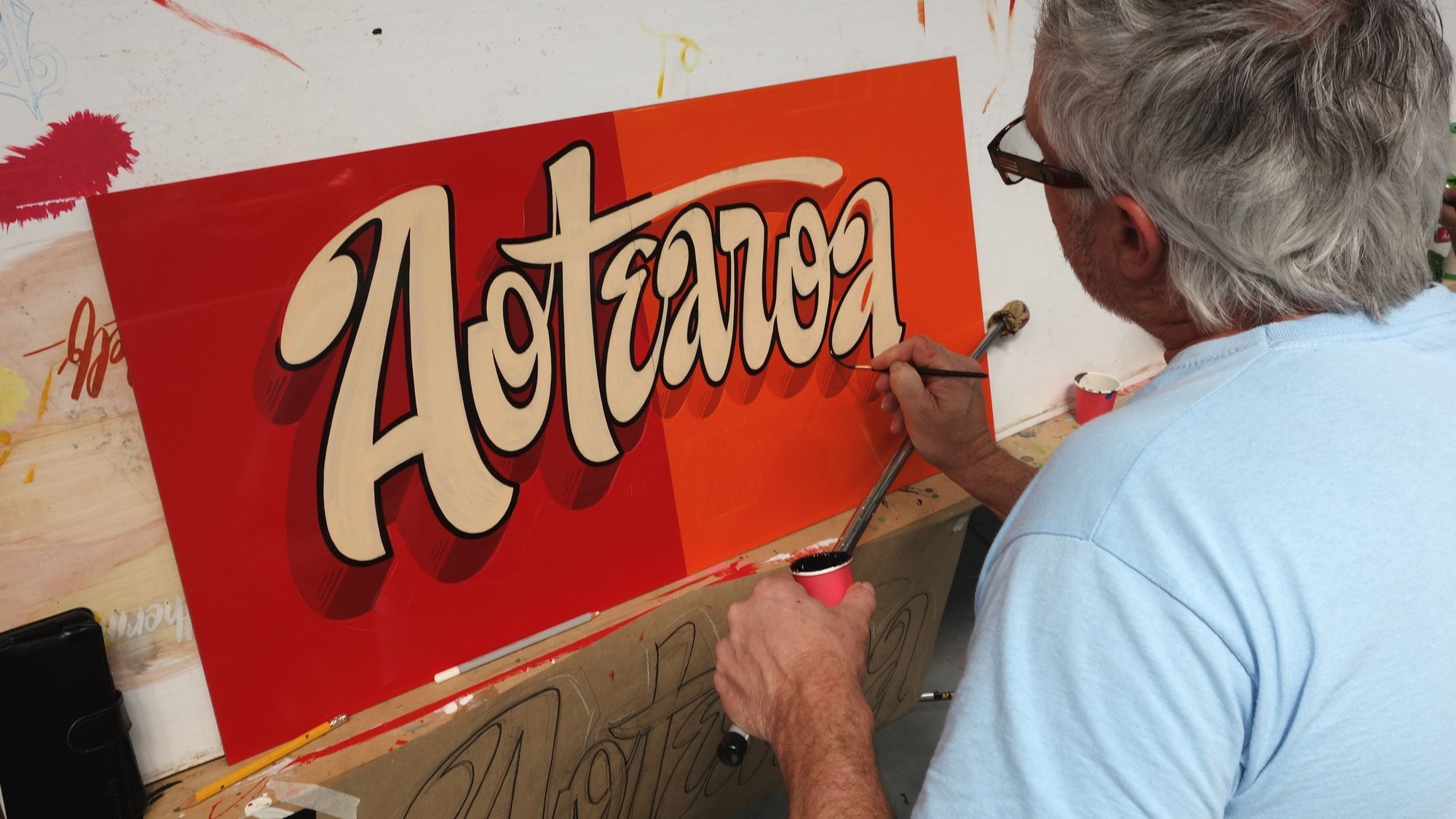 Man painting a sign.