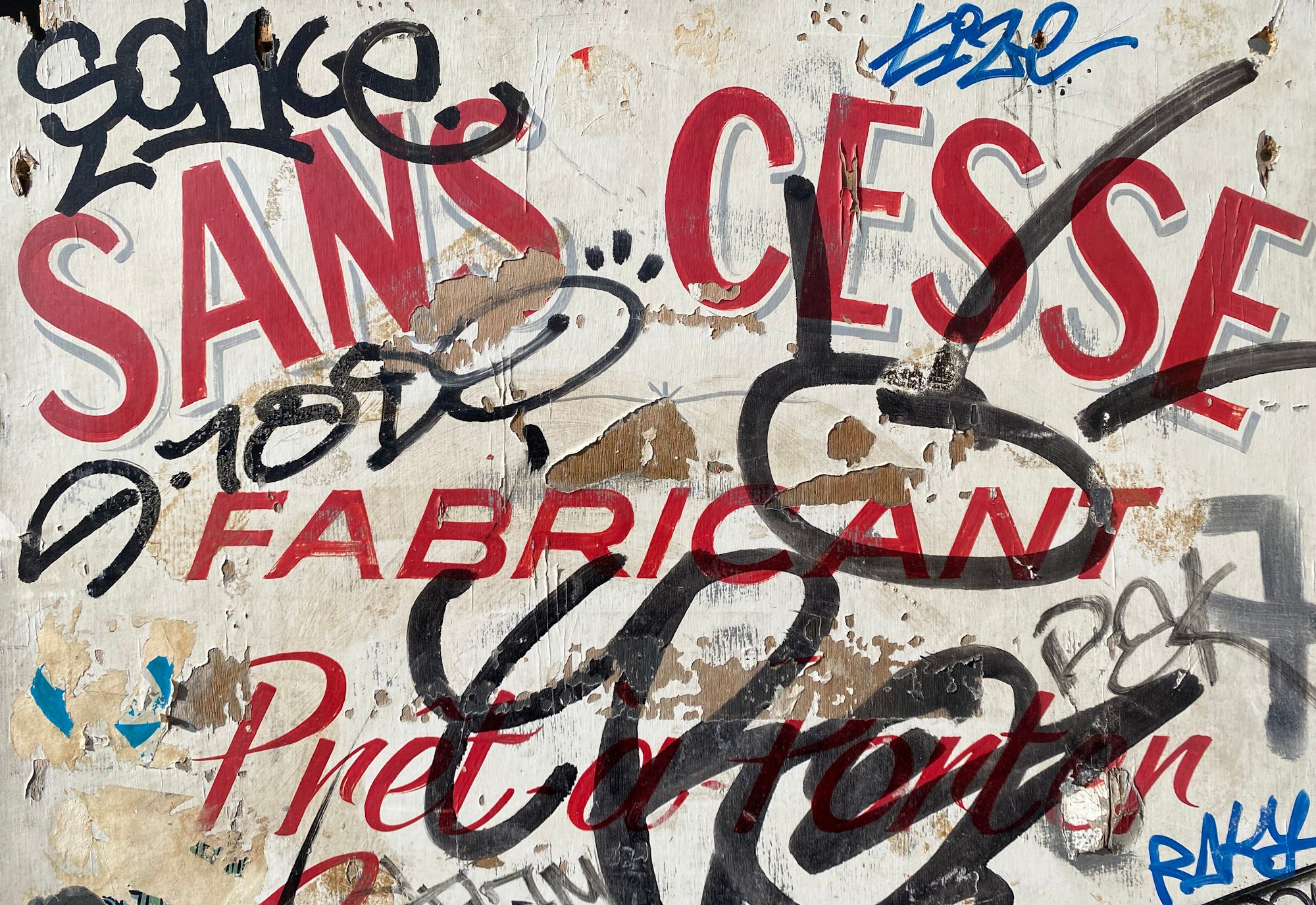 Detail of a hand-painted sign which has various graffiti tags in marker pen written over it.