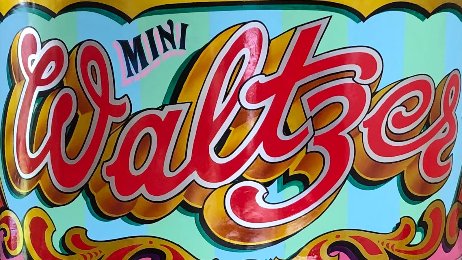 Curved side panel from a Waltzer fairground ride, lettered and flamboyantly decorated in bright colours and metal leaf.