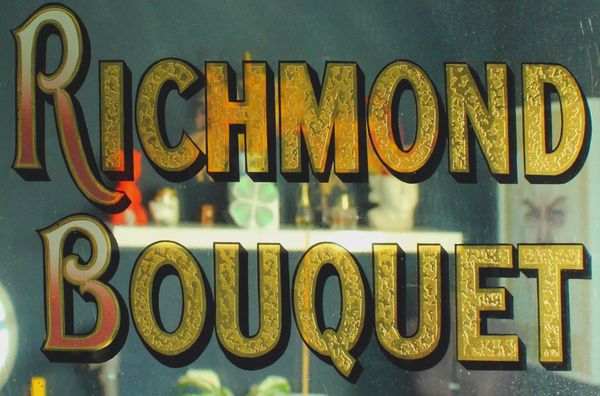 Gold leaf and painted letters on a mirror advertising Richmond Bouquet Cigarettes.