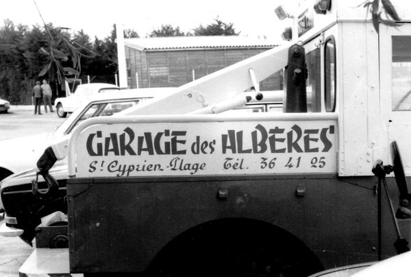 Tow truck with hand-painted lettering on the side.