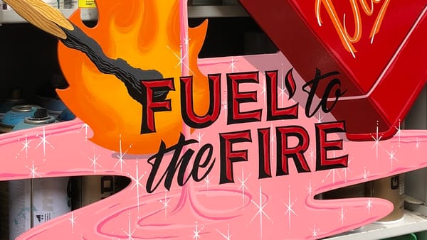 Detail of a painted panel showing a match igniting a pink liquid with lettering over the top that reads "Fuel to the fire".