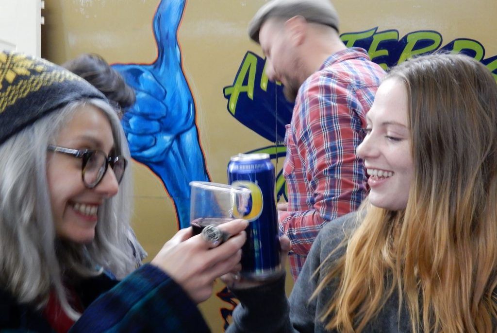 Cheers! Alice Mazzilli and Alex May Hughes share a brew, with Jaspter Andries from Amsterdam Sign Painters in the background