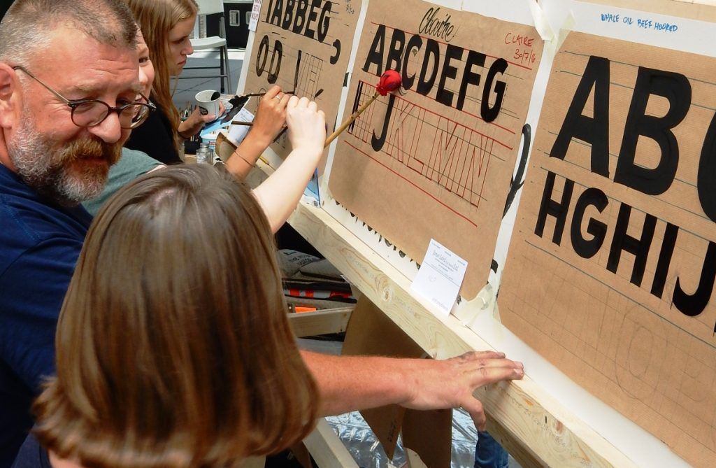 Day one and people are working the Gothic (Block) letters, first in pencil and then with paint