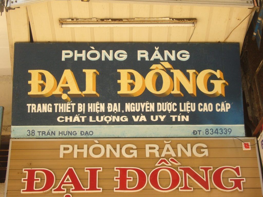 Hand-painted shop signs with Vietnamese lettering.
