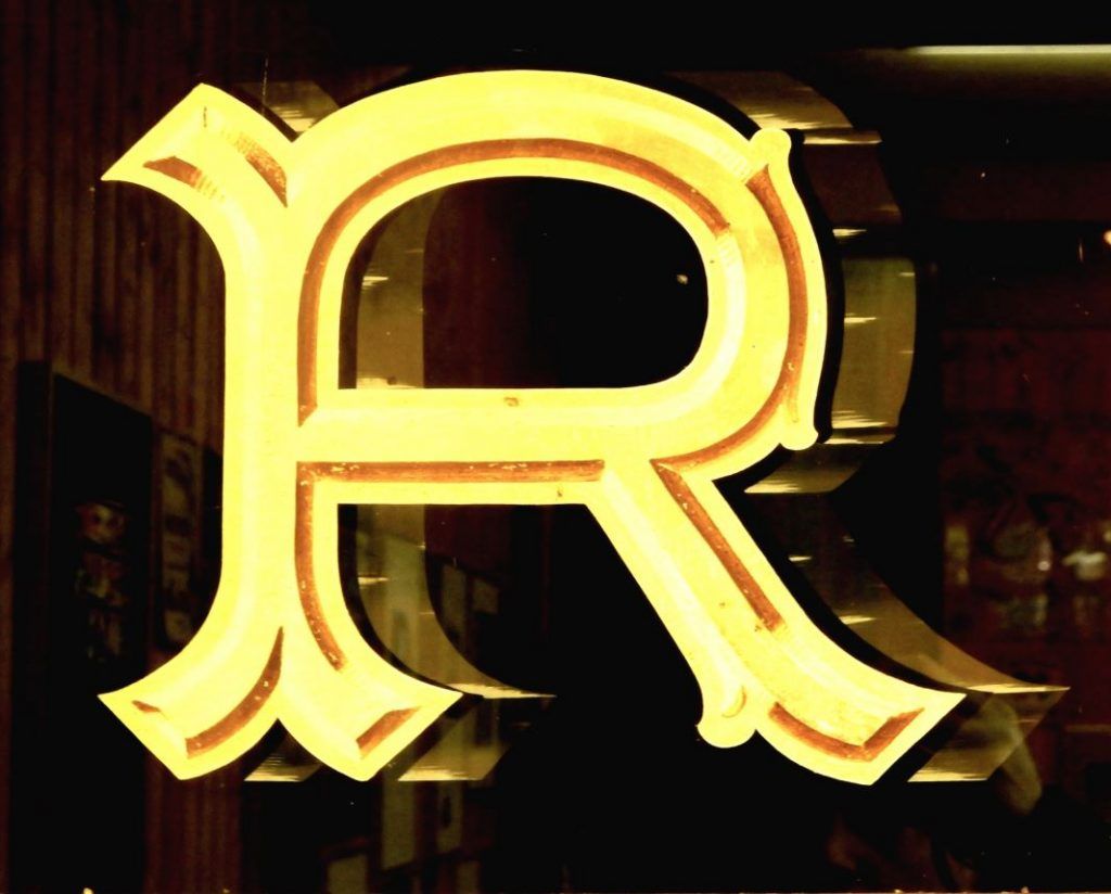 Gilded R on glass.