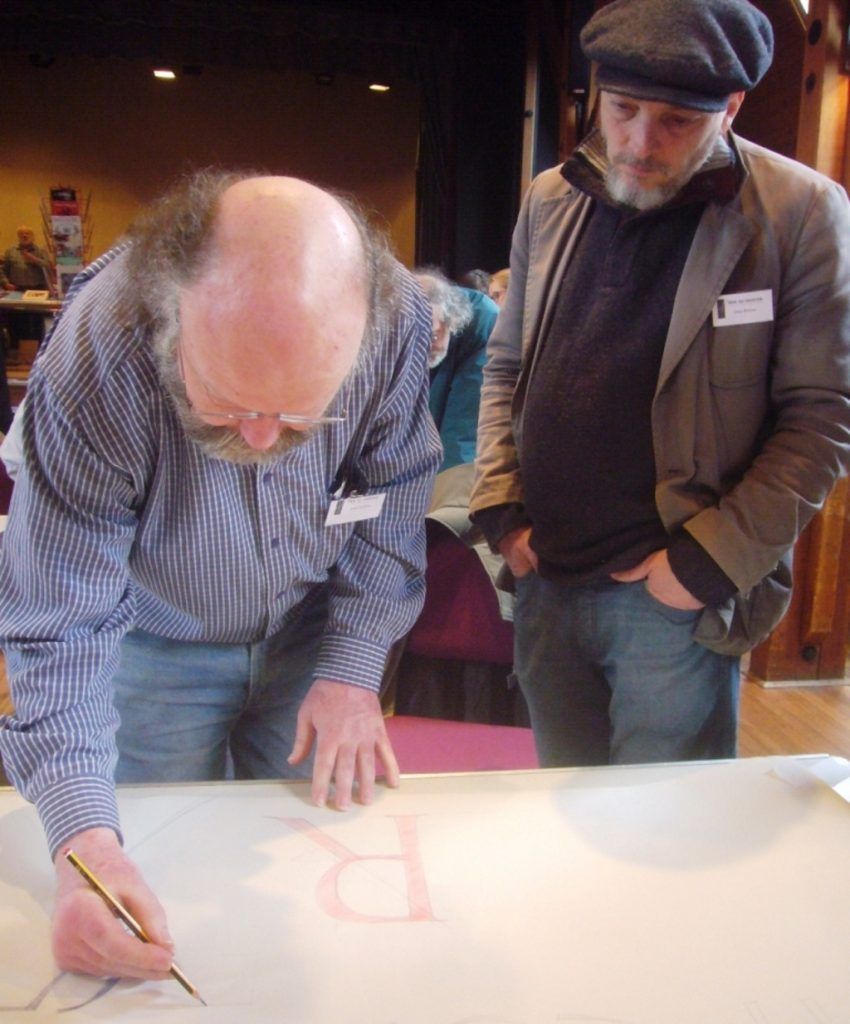 Gary Breeze observing Tom Perkins demonstrating his approach to lettering layout