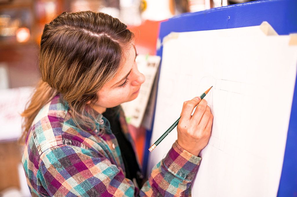 Getting started with a pencil and drawing the letters of a block alphabet.