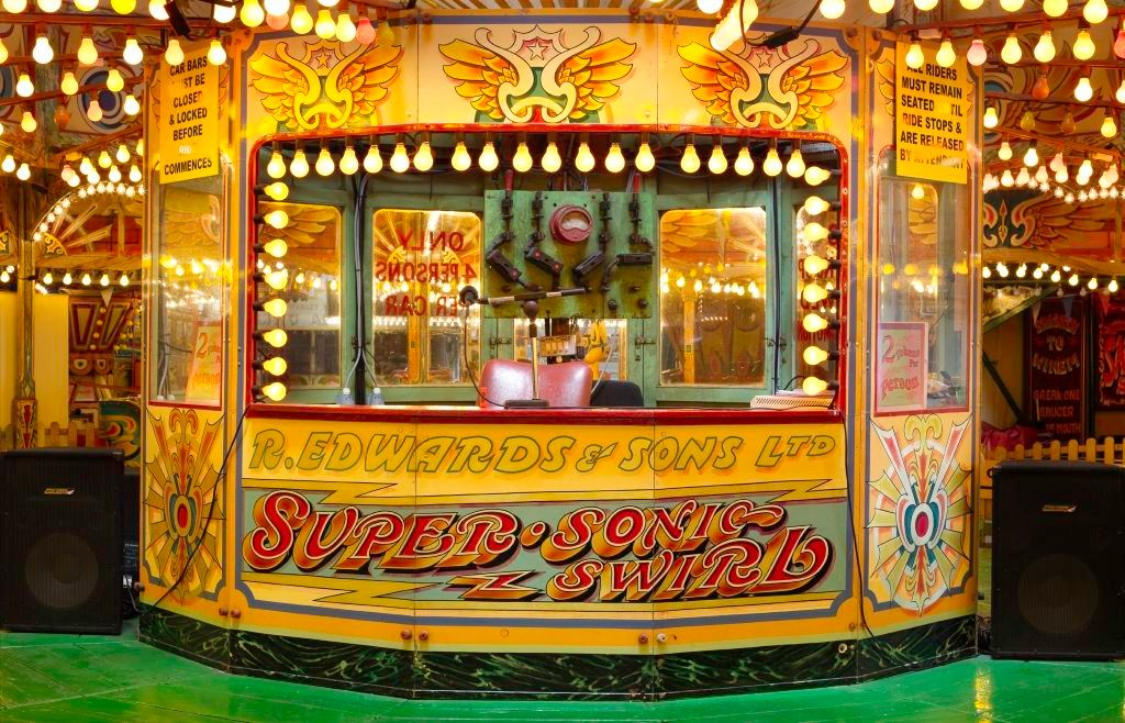 Ticket booth decorated with hand-painted and gilded lettering and fairground art.