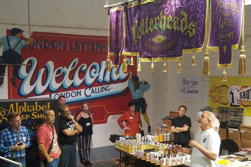 The welcome mural was painted by the Alphabetics Anonymous collective, and pictured here is Mark Oatis talking about the processes that he and his wife Rose used to create the ceremonial banner overhead.