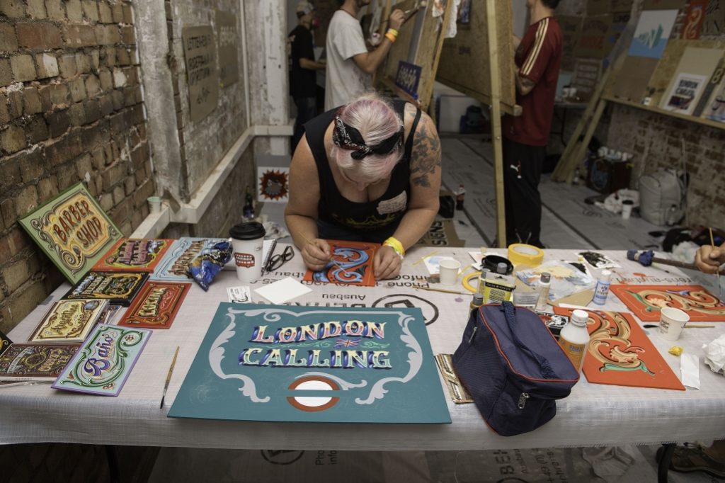 Lots of the workshops continued beyond their allocated slot, including Gustavo Ferrari (Ferrari Fileteado) and his Filete Porteño session. His piece in progress is shown here while Jane Lind Walker continues her work on a red panel.