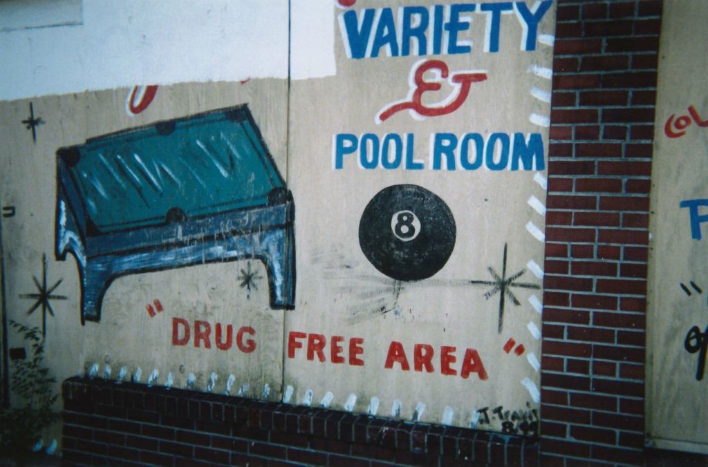 Painted lettering on a wall, which includes pictures of a pool table and 8-ball.