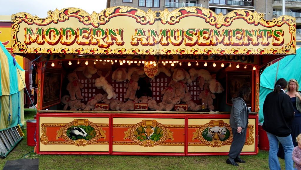 Flamboyantly hand-painted and gilded fairground stand with lettering and fairground art.